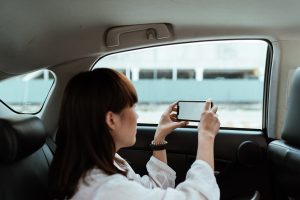 A tourist taking pictures and connected to a portable device